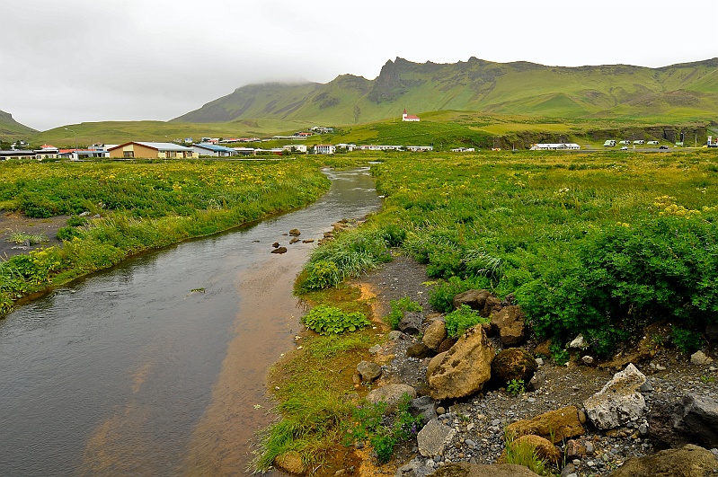 ABC_6420.jpg - Sur la c�te sud, se trouve le village de V�k, appel� aussi V�k i Myrdal. Comme tous les villages, il poss�de sa petite �glise perch�e sur les hauteurs et domin�e par d'impressionnantes montagnes.